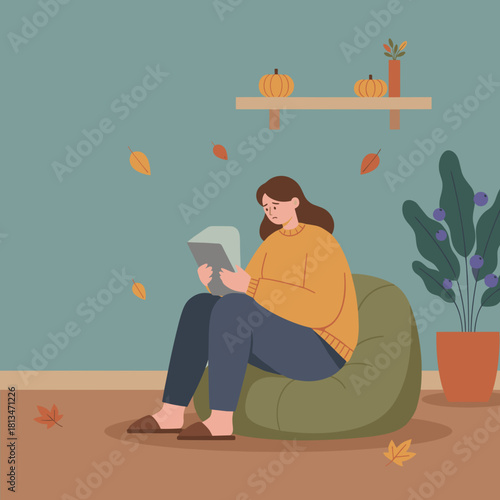 Solitary woman reading tablet indoors on an autumn day Feeling lonely or bored during the fall season