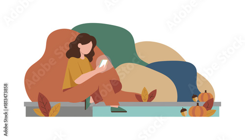 Casual autumn leisure Woman using a mobile phone outdoors in a park setting