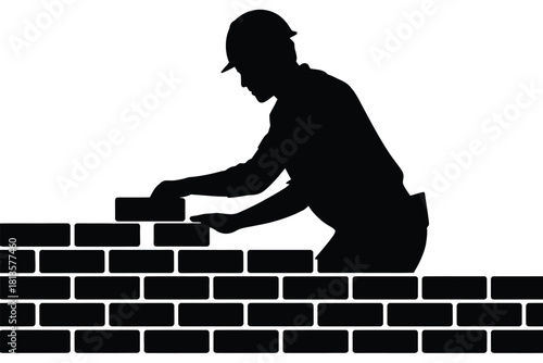 Silhouette of a construction worker laying bricks on a wall