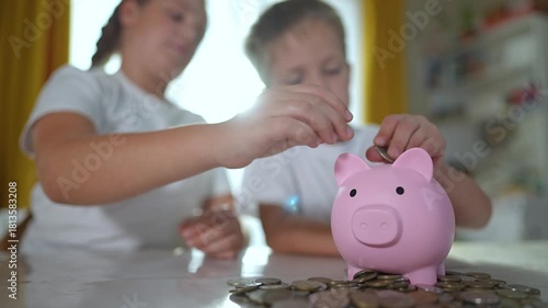 Children saving coins piggybank, learning finance at home. Family teaching Children financial responsibility. Concept family financial education. Children using piggybank, developing finance habits.