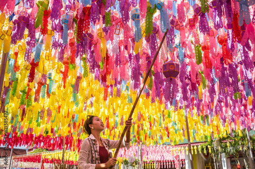 Asian woman hanging a paper lantern, Lamphun, Chiang Mai, Thailand