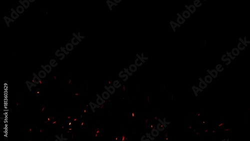 Fiery sparks rising slowly on dark background in cinematic motion