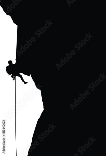 Silhouette of rock climber rappelling down a steep cliff face