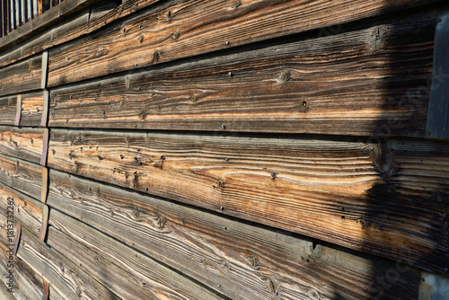 経年変化した古い横張りの板壁とさびた金属バンドのテクスチャー