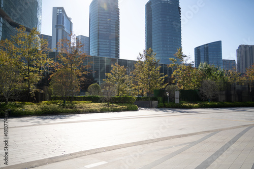 modern city scene with tall glass buildings and green trees