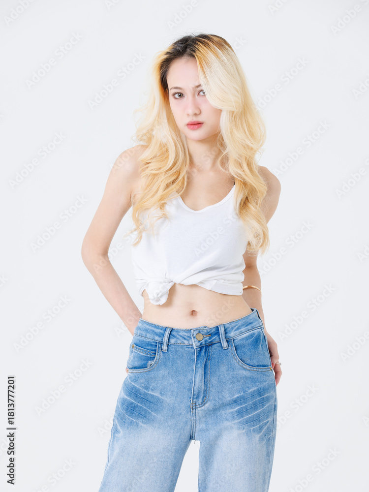 Fototapeta premium Asian confident beautiful attractive young woman blonde long hair stand wear sleeveless top jeans on white background studio, portrait lifestyle fashion street outfit trendy style pose look at camera.