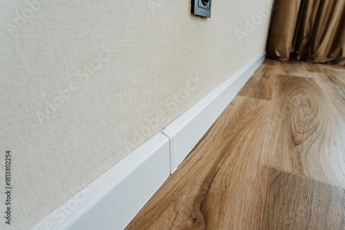 contemporary design showcasing minimal edges and coordinated color scheme, stylish white baseboard paired with natural light illuminating modern wooden flooring setup for lifestyle imagery