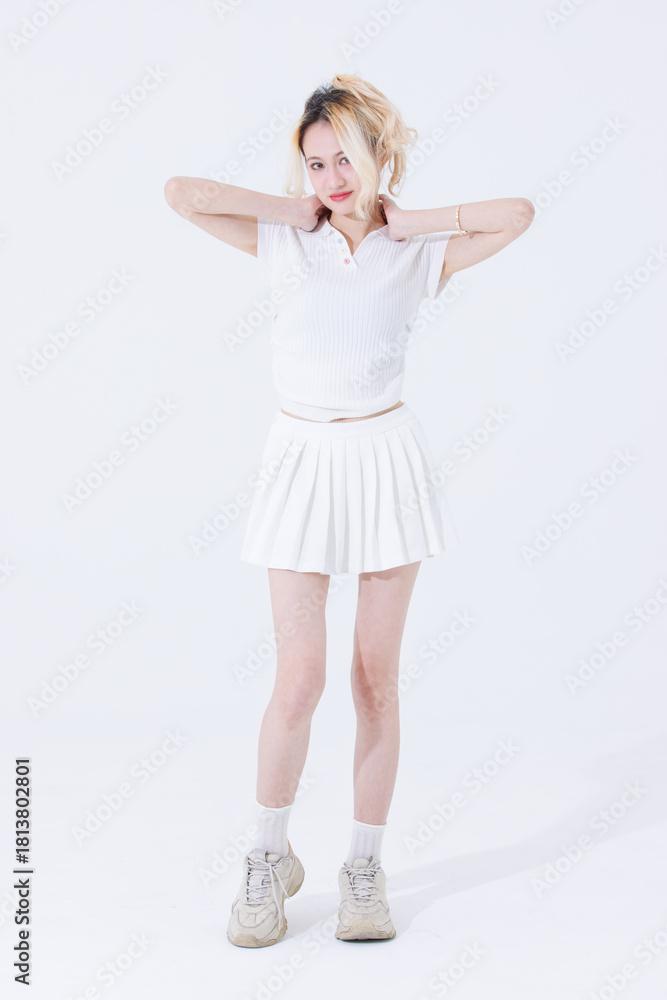 Naklejka premium Asian confident attractive beautiful woman blonde hair tied stand wear white shirt top mini skirt sport on background studio portrait fashion street outfit trendy style pose look at camera full length