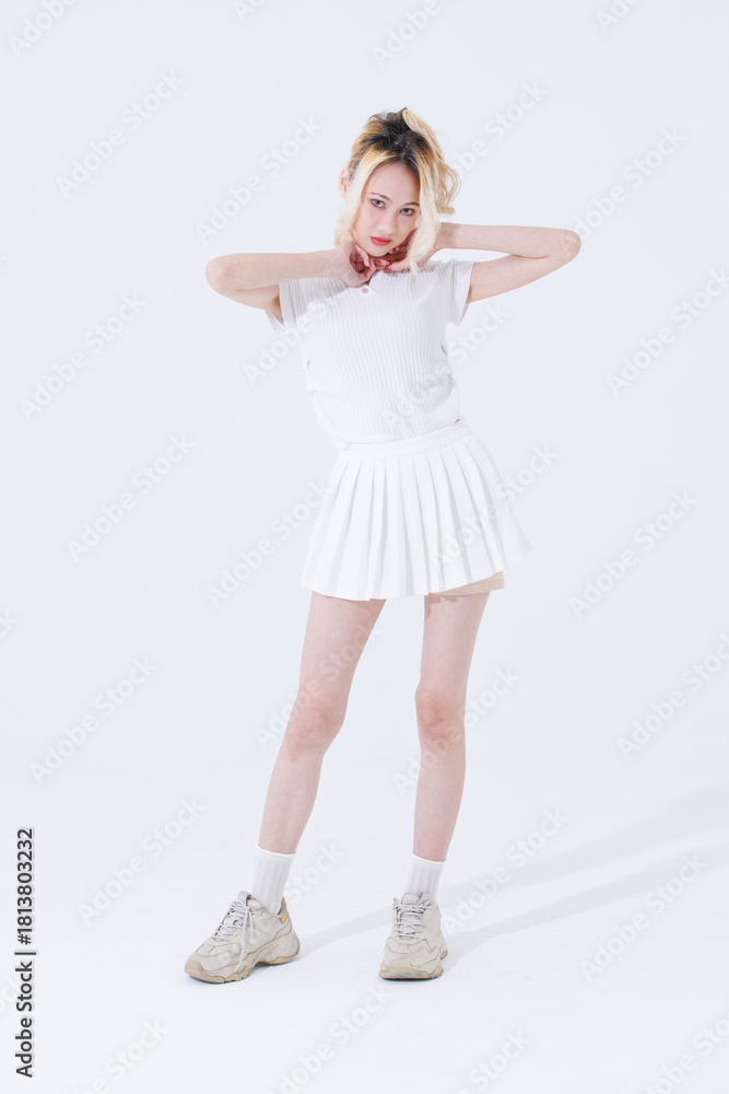 Naklejka premium Asian confident attractive beautiful woman blonde hair tied stand wear white shirt top mini skirt sport on background studio portrait fashion street outfit trendy style pose look at camera full length