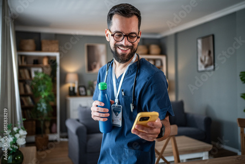 Male healthcare worker relaxing at home checking phone
