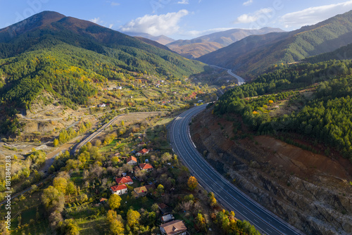 Cuadro en lienzo Aerial view of the A1 motorway winding through the mountain valleys of Mirdita, surrounded by autumn forests and scattered hillside homes
