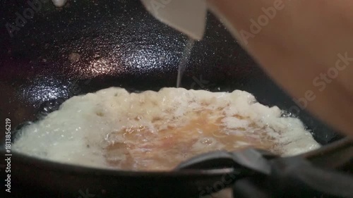 Thai Omelette Cooking Puffing Up in Hot Oil. Crispy Texture Street Food Style