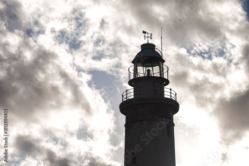 Paphos Lighthouse towering over the landscape casting a shadow on cloudy day. Cyprus