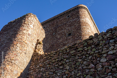 Stone and Blue Architecture: Textured Close-up of Wall and Defensive Tower.