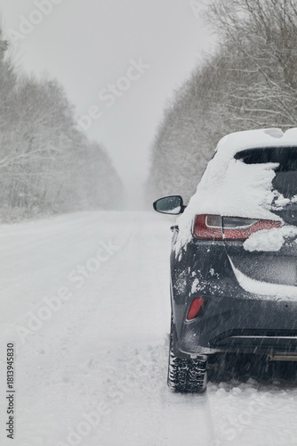 A gray car on a winter road in snowfall, close up