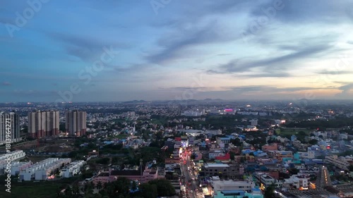 Wallpaper Mural Chennai’s cityscape at twilight shows dense older streets in the foreground and apartment towers beyond. Streetlights and traffic trails brighten the scene, with distant hills visible on the horizon. Torontodigital.ca