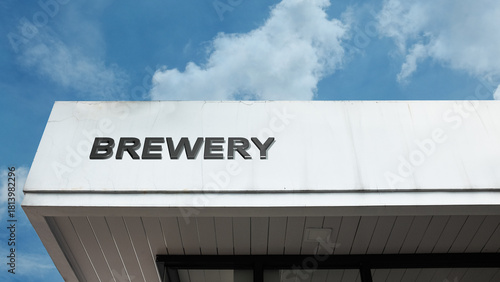 Brewery word sign displayed on building under clear blue sky, representing beer production, craft brewing, beverages, and industrial drink making