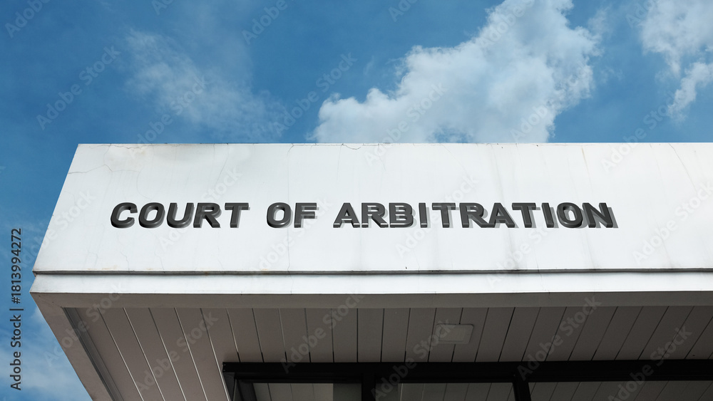 Obraz premium Court of Arbitration word sign displayed on a building under a clear blue sky, representing legal dispute resolution, mediation, judiciary, and government administration