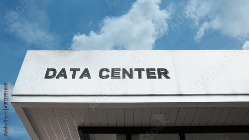 Data Center word sign on a building under a clear blue sky, symbolizing technology, servers, IT infrastructure, networking, security, operations, and digital services