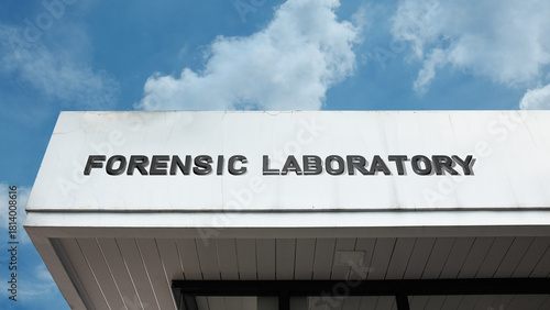 Forensic Laboratory word sign mounted on a modern building under a bright blue sky, symbolizing investigation, evidence analysis, science, and criminal research