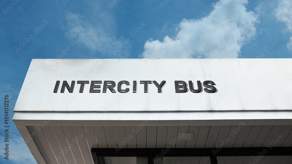 Obraz premium Intercity Bus sign on a building against a clear blue sky, symbolizing public transport, long-distance travel, terminal, road connectivity, and station