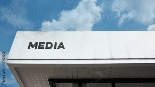 Media sign on a building against a clear blue sky, symbolizing communication, information dissemination, broadcasting, news production, technology, and press