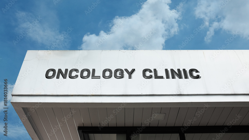 Obraz premium Oncology Clinic word signage on a specialized medical building under a blue sky, symbolizing cancer treatment, healthcare, clinical research, and hope