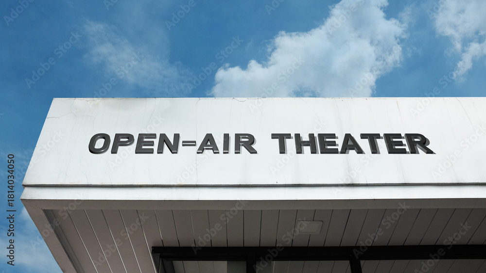Obraz premium Open-Air Theater word signage on an entertainment structure under a blue sky, symbolizing arts, outdoor performance, culture, and public leisure venue