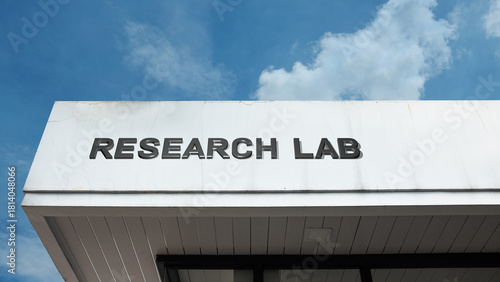 Research Lab word signage on a scientific or corporate building under a blue sky, symbolizing experiment, scientific inquiry, technological development, discovery, and innovation center