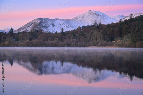 Beautiful winter reflections of snowcapped mountains at Derwentwater in The Lake District, UK.