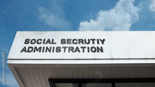 Social Security Administration word signage on a government building under a blue sky, symbolizing public benefits, retirement, federal agency, government services, welfare, and public aid