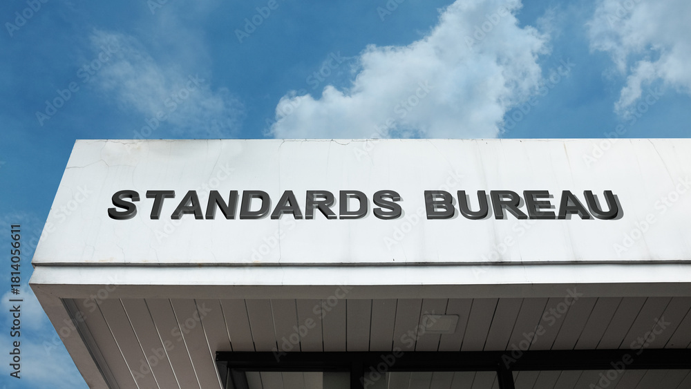 Obraz premium Standards Bureau word signage on a government or regulatory building under a blue sky, symbolizing quality control, official regulation, measurement, certification, research, consistency, and metrolog