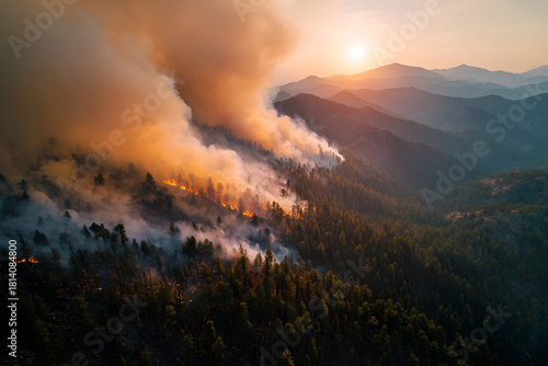 Dramatic aerial view of catastrophic wildfire during sunset over forested mountains
