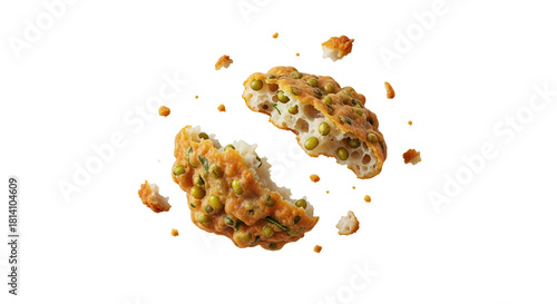 Elevated view of a split pea fritter with scattered crumbs against a crisp white background highlighting its culinary appeal and homemade aesthetic