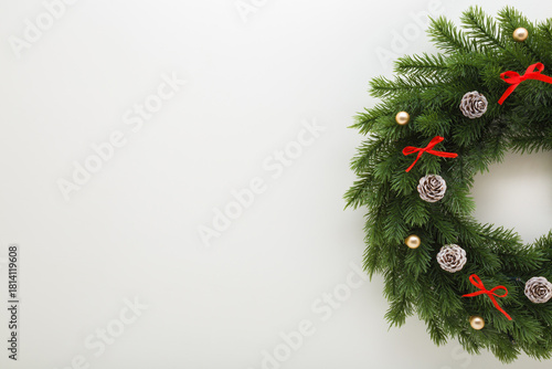 Green fir wreath with decoration on light gray table background. Christmas door wreath. Closeup. Flat lay. Empty place for text. Top down view.