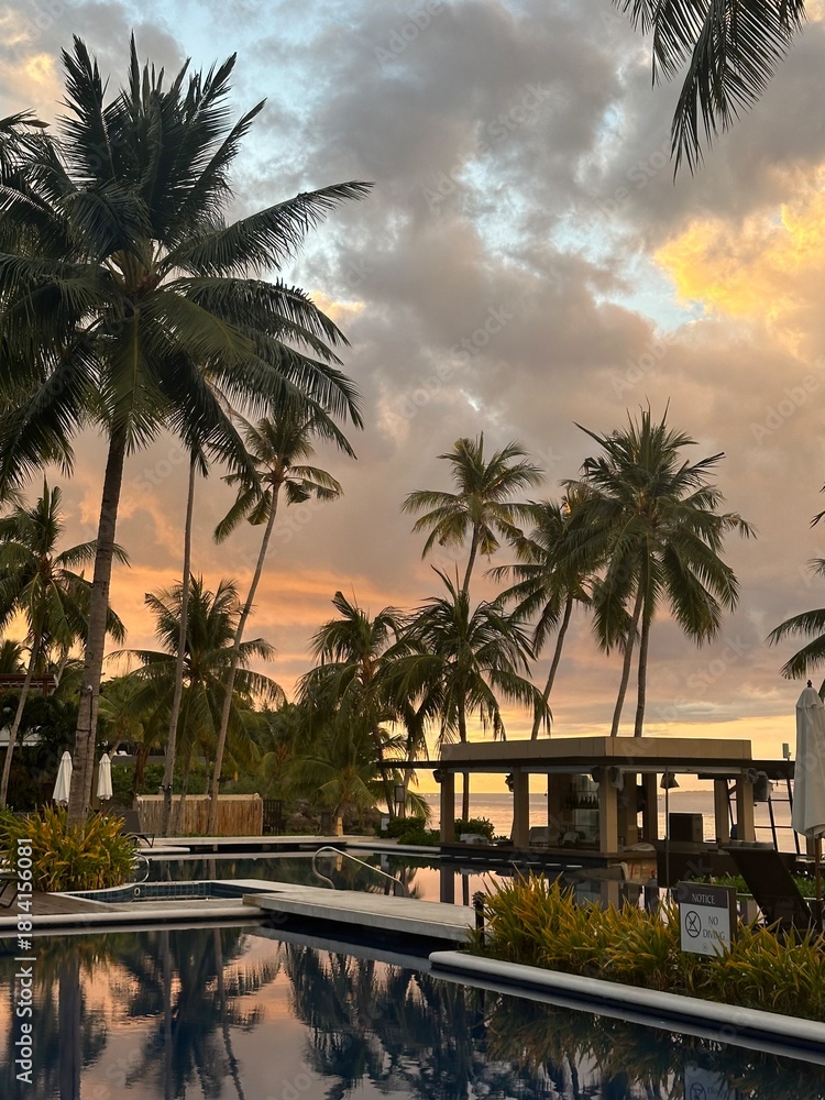 Obraz premium Sunset Reflections at Tropical Resort Pool with Palm Trees, Philippines