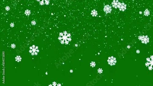 Falling white snowflakes and snow particles on a green screen background for winter holiday season