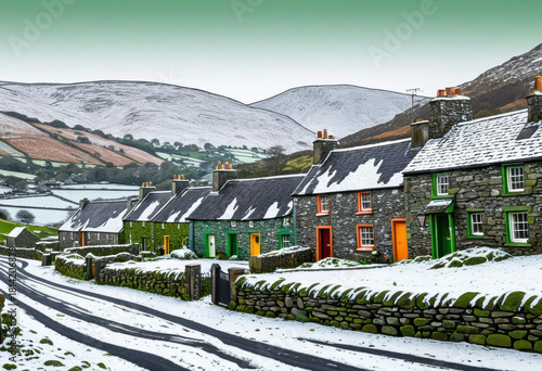 Traditional Irish stone cottages in a village under a light dusting of snow, green hills in background
