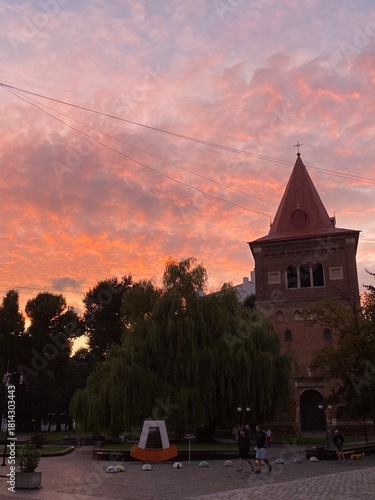 Pink sunset over historic city silhouette with illuminated sky