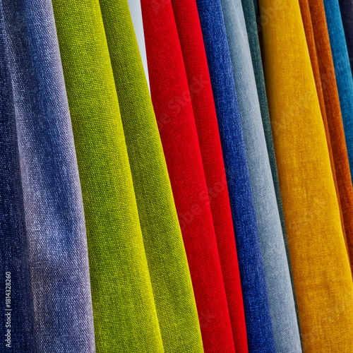 Colorful fabric swatches hanging in a row showing vibrant textile textures and variety of materials