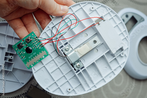 Fotografi Disassembled electronic device kitchen scales with circuit board wires plastic parts on a table