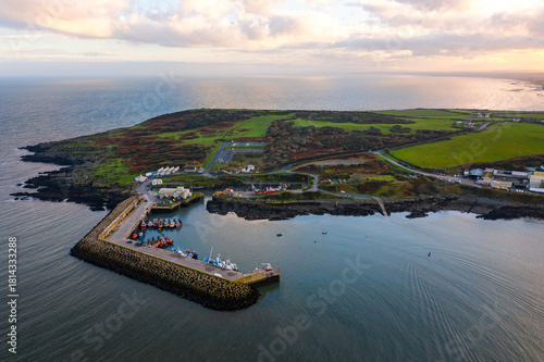 Aerial view of Port Oriel in Clogherhead with fishing boats and hazy evening light along the calm coastline