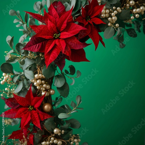 Holiday Wreath With Red Flowers and Green Leaves Against a Green Background