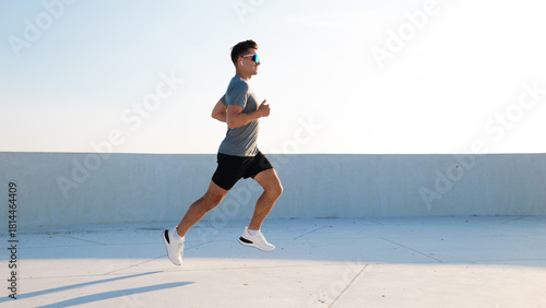 Runner exercises on rooftop at sunset
