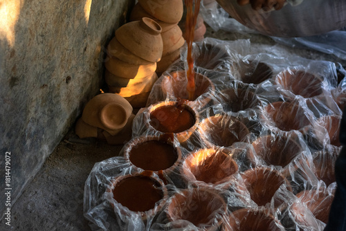 Artisanal Food Craft: Rows of Unrefined Sugar Setting Near Stacked Clay Pots