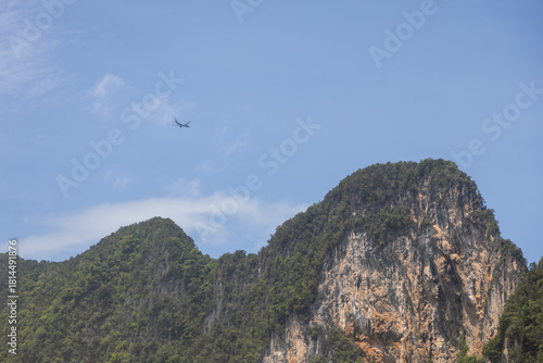A large plane is flying over the mountains.