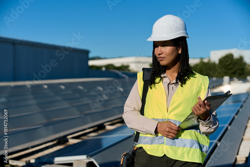 Woman engineer inspecting solar panels on rooftop