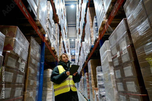 Woman worker checking inventory in cold storage warehouse