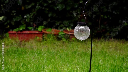 Composition of wooden parquet and grass in an outdoor setting during rainy weather. Focus and depth of field are selective. A romantic rainy landscape in the garden.
