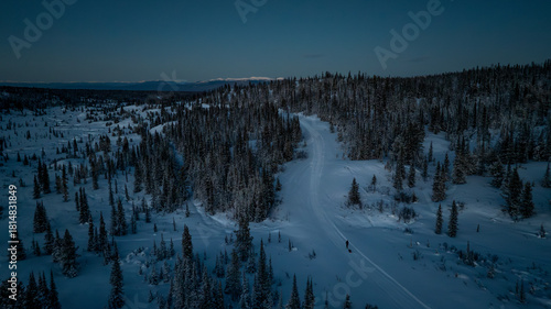 Lone adventurer walking through a froze winter landscape pulling a sled.
